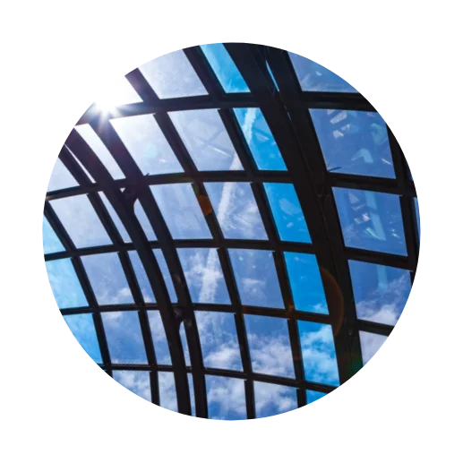 Glass roof structure against a blue sky